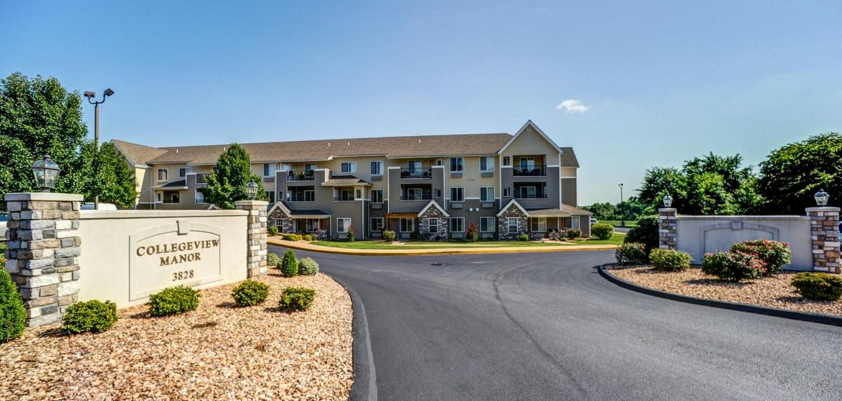 A modern suburban apartment complex with landscaped surroundings and a clear blue sky.