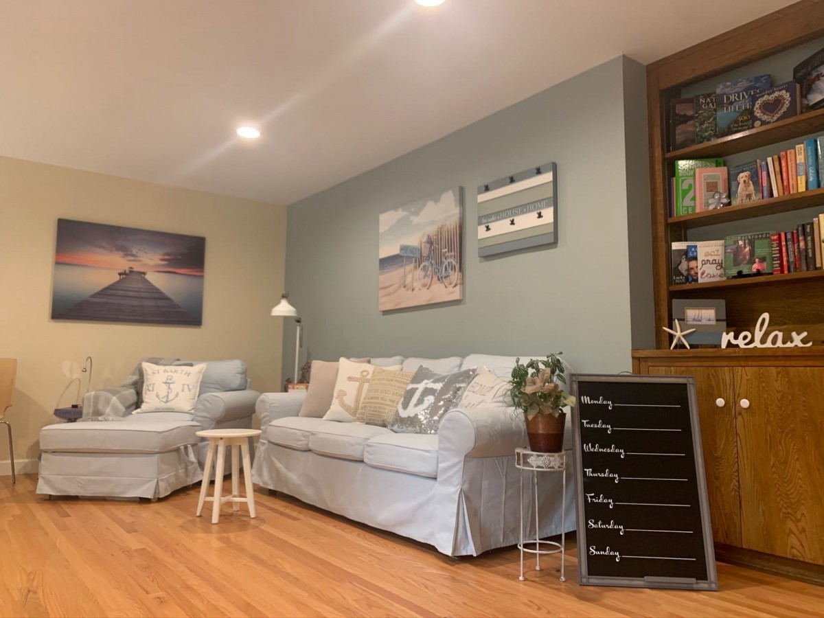 A cozy living room with comfortable seating, decorative wall art, and a touch of greenery.