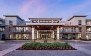 Modern architectural building with a landscaped entrance under a blue sky.