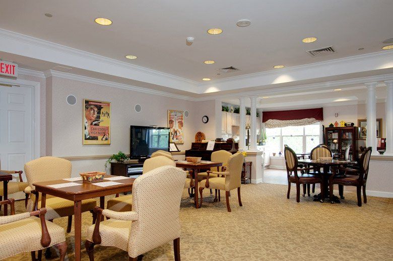 A cozy dining area with tables and chairs in a senior living facility.
