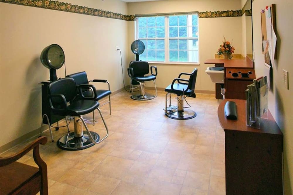 An empty hair salon with chairs and dryers arranged neatly.