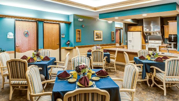 A cozy dining area featuring elegantly set tables and comfortable chairs, with warm lighting and stylish dcor.