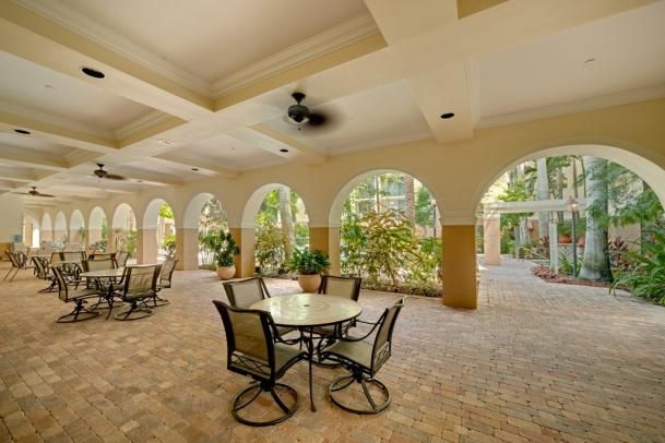A charming patio with arched openings and outdoor seating overlooking a garden.