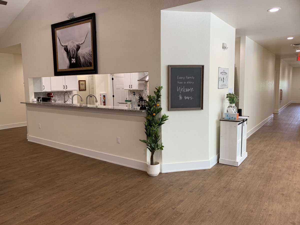A modern reception area with a desk, plants, and artwork on the walls.