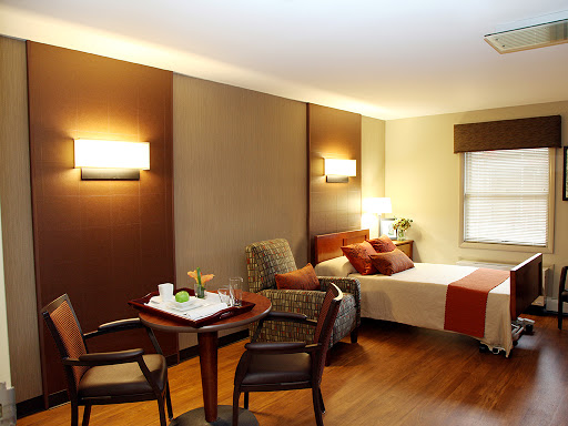 A cozy hotel room featuring a comfortable bed, seating area, and modern lighting.
