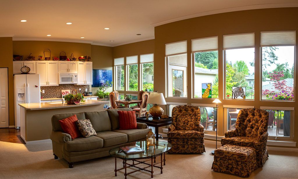 A cozy and well-lit living room with modern furniture and large windows that bring in natural light.
