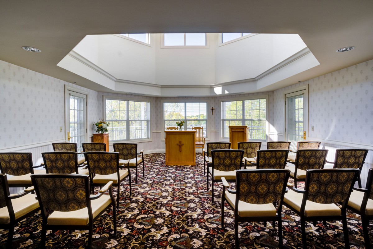 A peaceful chapel interior with arranged chairs and natural light streaming through the windows.