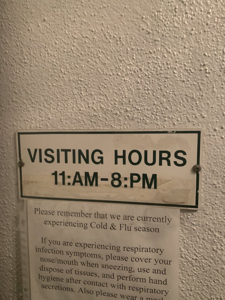 A sign displaying visiting hours from 11 AM to 8 PM.
