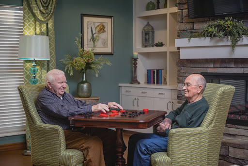Two elderly friends enjoying a game together in a cozy indoor setting.