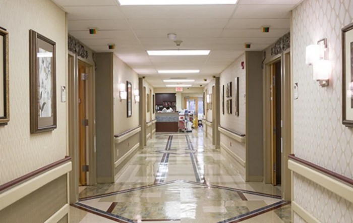 A clean and well-lit hospital corridor leading to a reception area.