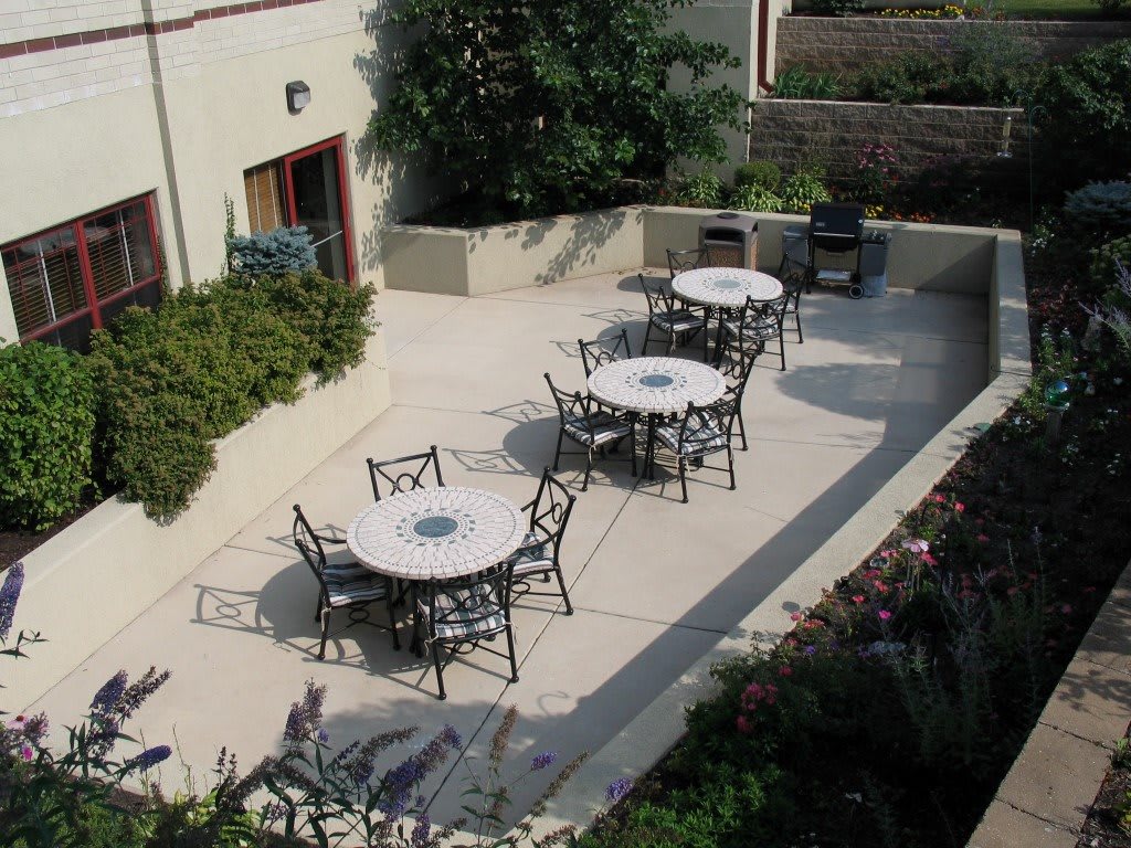 An outdoor patio area with several tables and chairs arranged for seating.