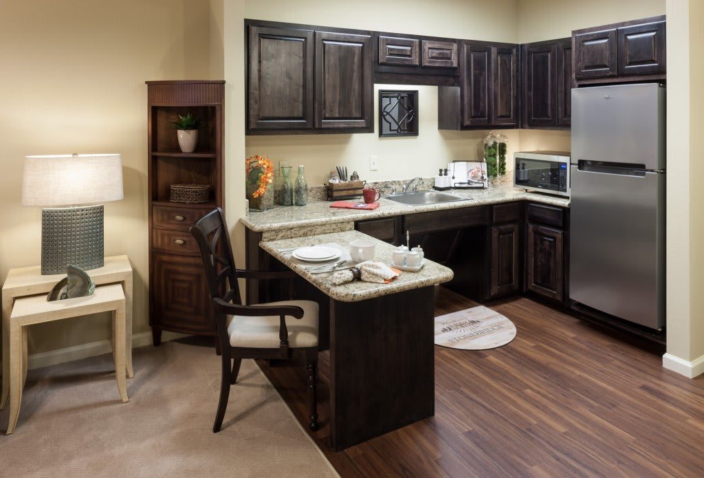 A modern kitchen with dark cabinets and a cozy dining area.