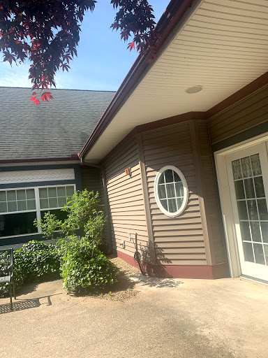 A charming view of a house exterior with lush greenery and unique architectural features.