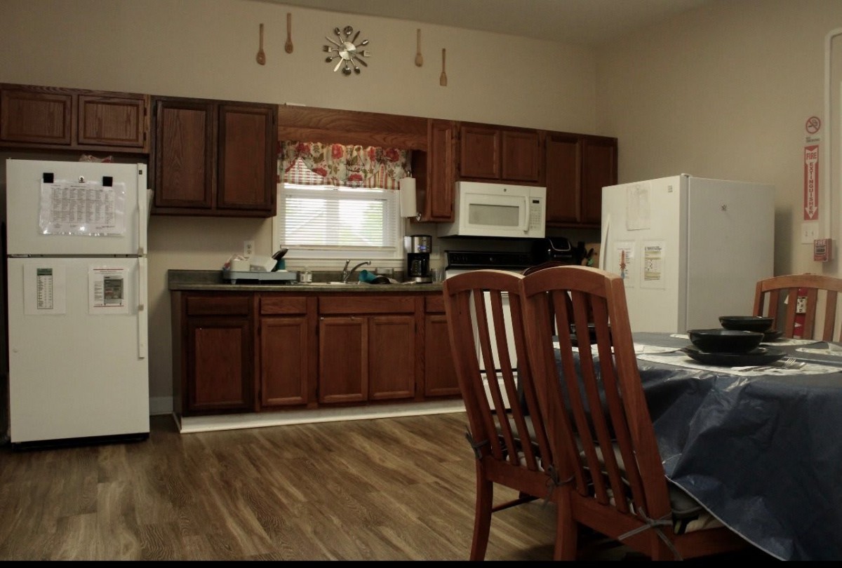 A cozy kitchen with wooden cabinets and a dining area featuring a table and chairs.