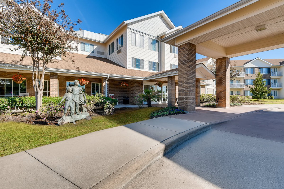 A modern residential building with a welcoming entrance and landscaped surroundings.