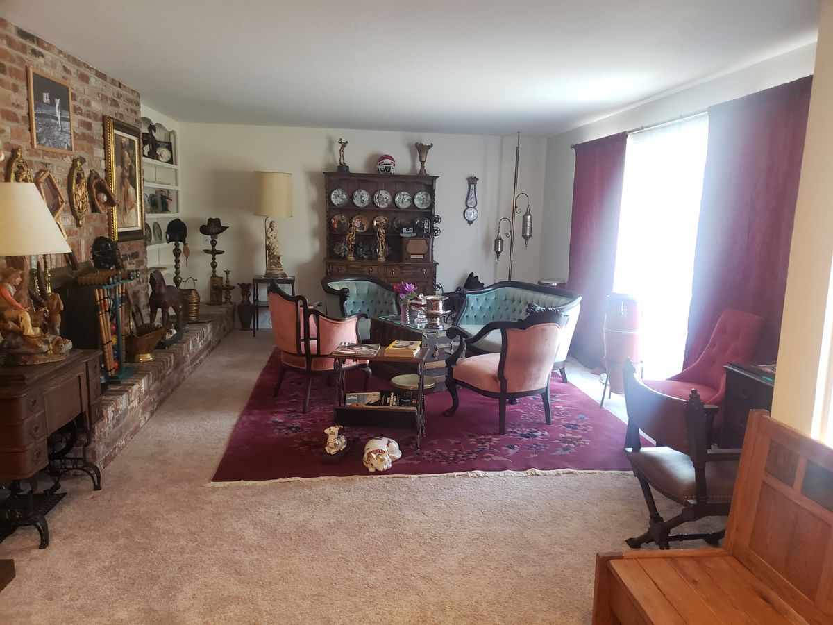 A vintage-styled living room with classic furniture and a china cabinet.