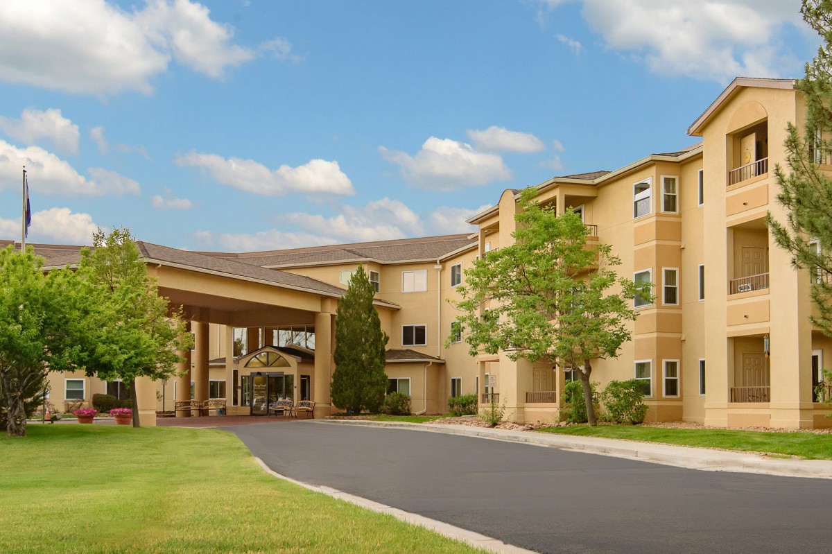 The exterior view of a hotel with a welcoming entrance and surrounding greenery.