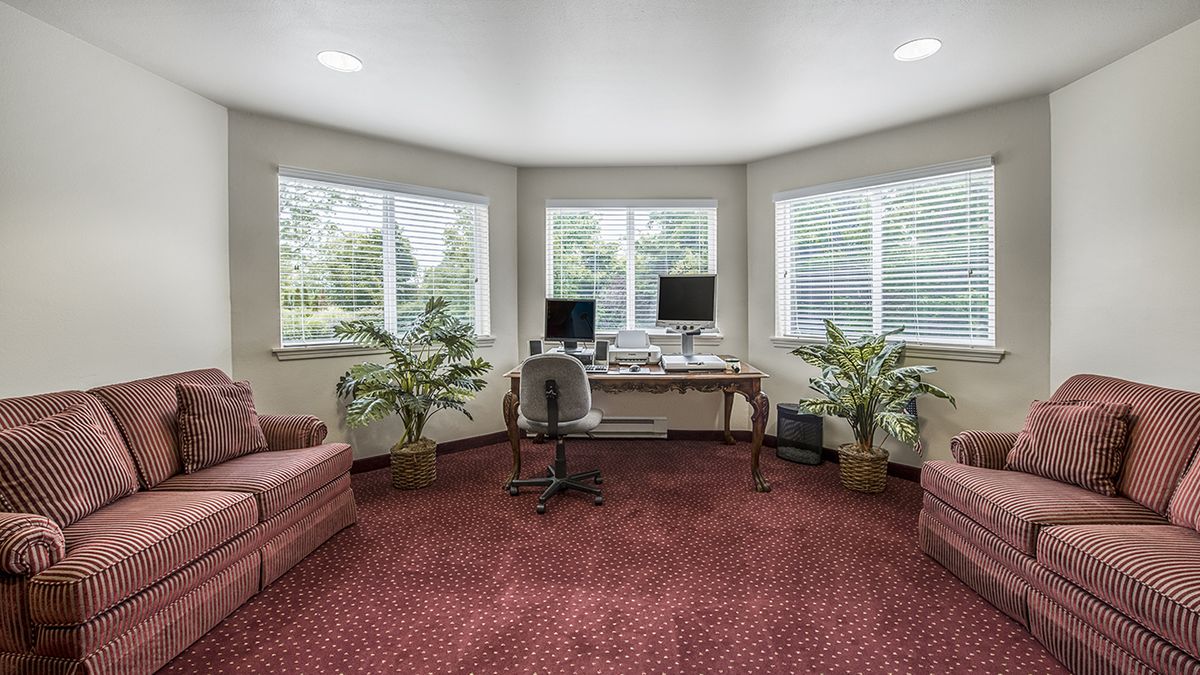 A cozy home office with large windows and a view of the outdoors.