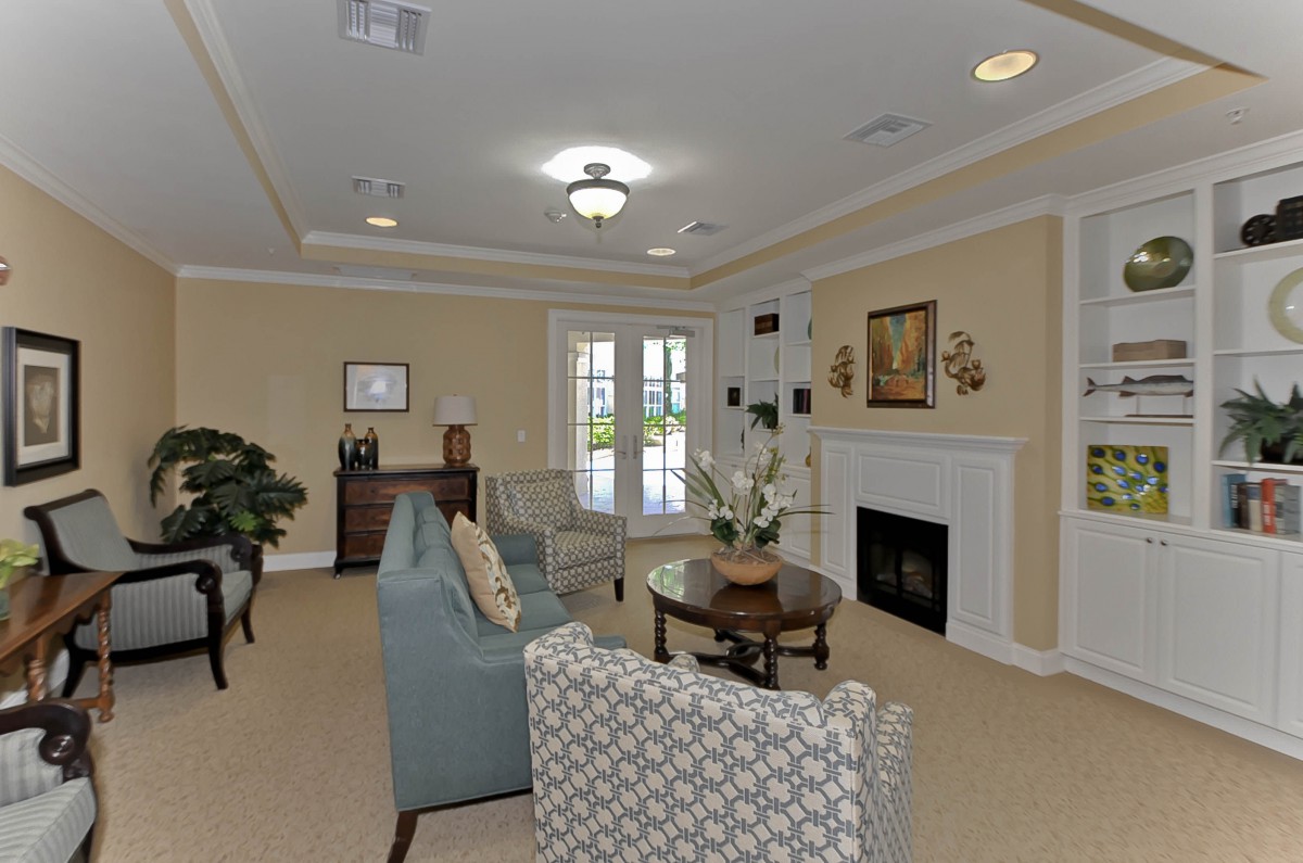 A cozy living room featuring a sofa and armchair set, with a fireplace and coffee table as central elements of the decor.