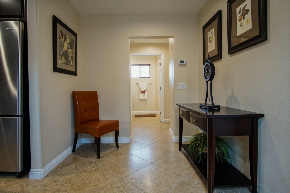 A well-decorated hallway featuring a chair, table, and framed artwork.