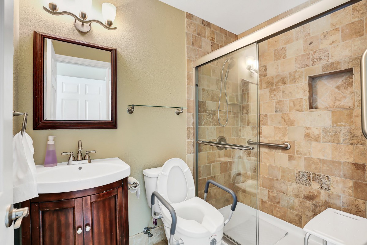 A well-appointed bathroom featuring a toilet, sink, and tiled shower area with a glass door.