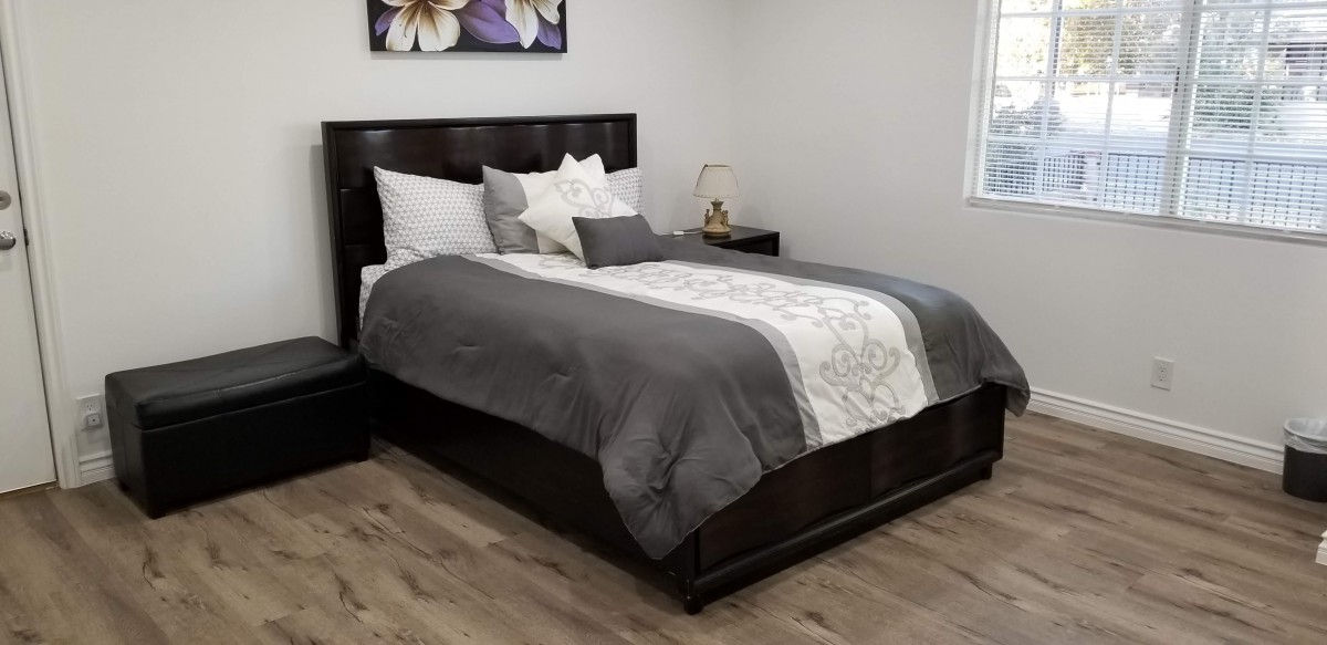 A neatly arranged bedroom with a stylish bed and elegant decor.