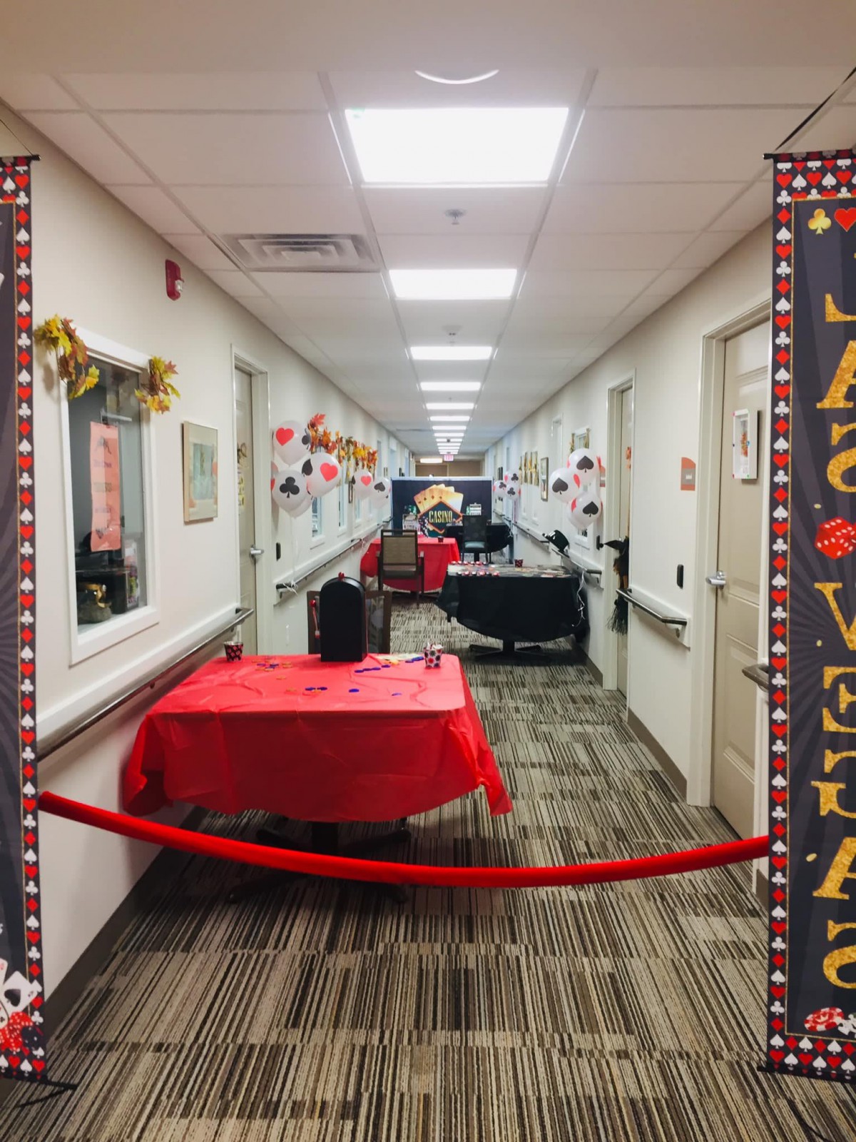 A decorated hallway with festive streamers and a red tablecloth, ready for a celebration.