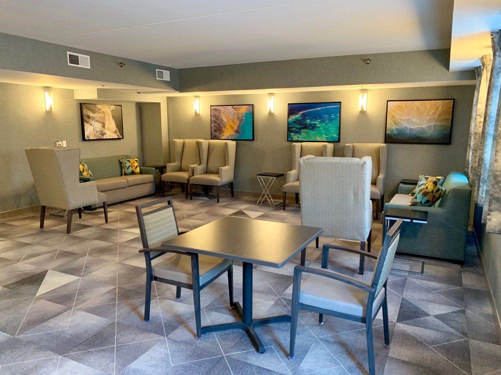 A comfortable lounge area with various seating options and decorative artwork on the walls.