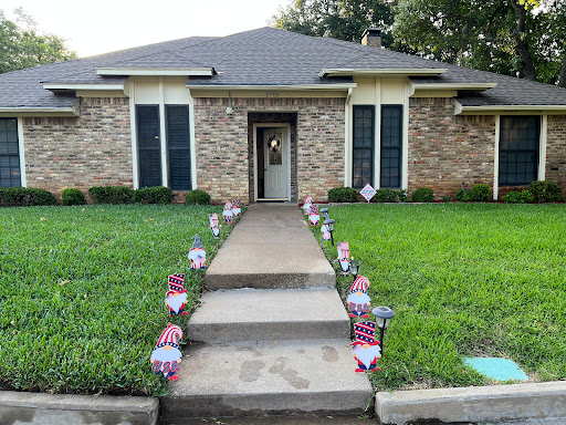 A charming home with a neatly landscaped front yard, featuring decorative garden gnomes along the walkway.