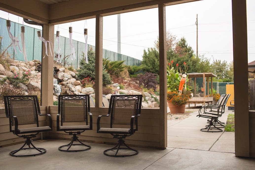 A cozy patio with swivel chairs overlooking a landscaped garden.