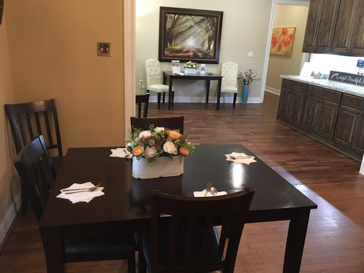 A cozy dining area featuring a beautifully set table with a floral centerpiece.