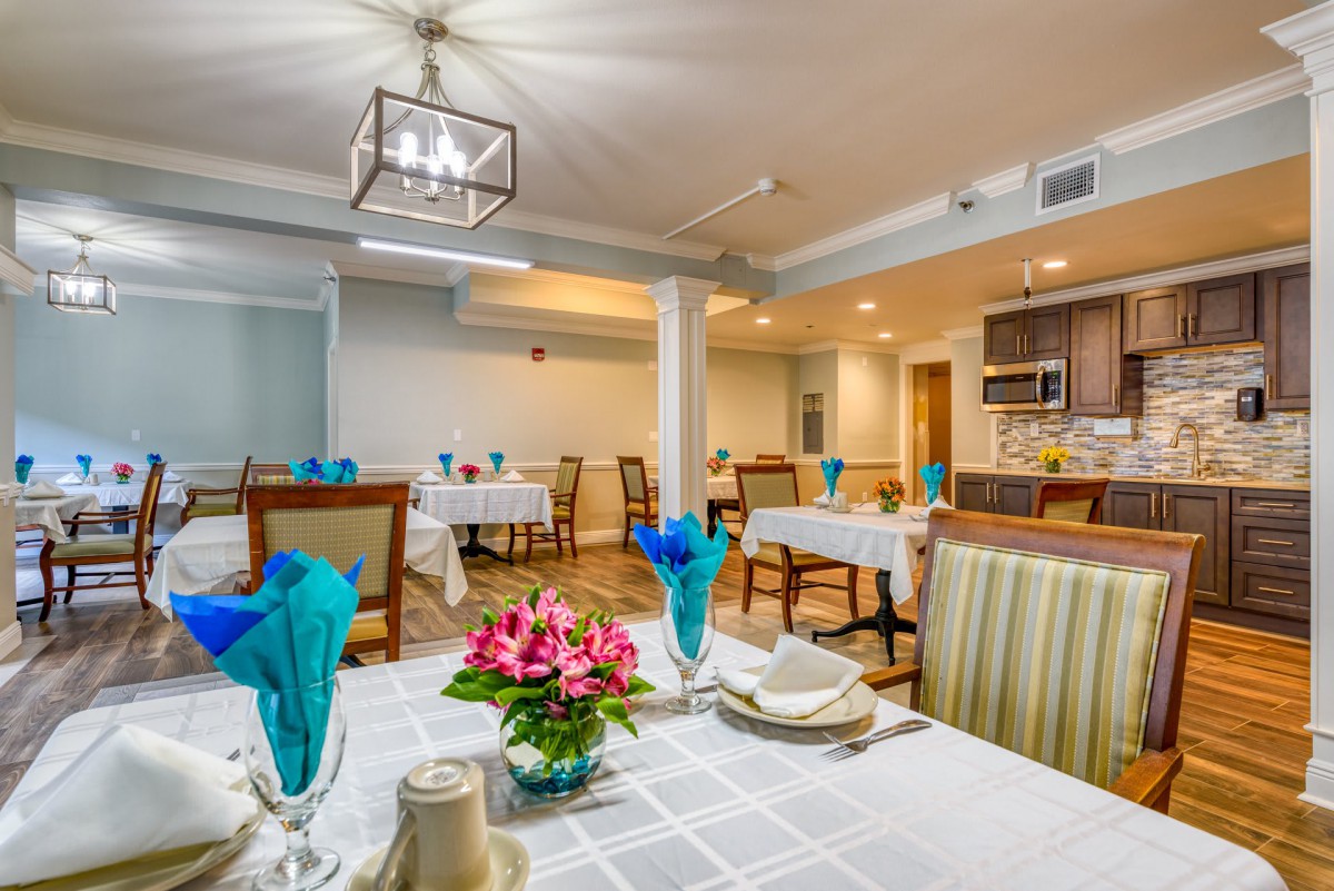 A well-decorated dining room with elegantly set tables and floral decorations.