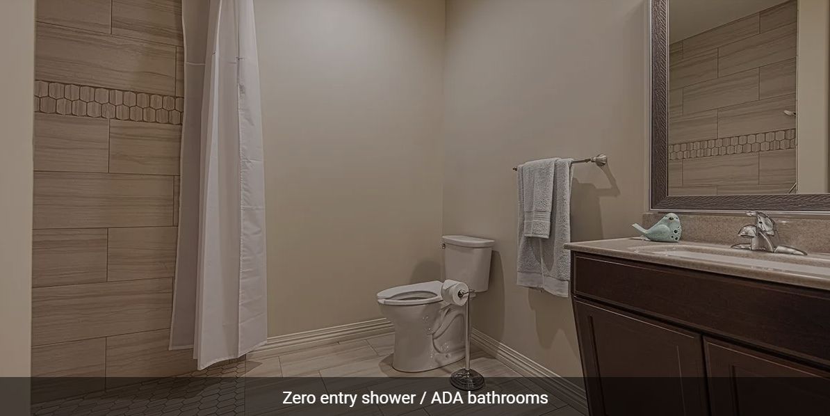 An ADA-compliant bathroom featuring a zero entry shower and essential accessibility features.