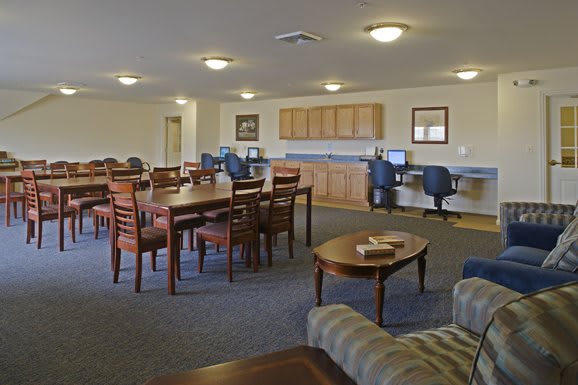 A spacious community room with tables, chairs, and computer stations.