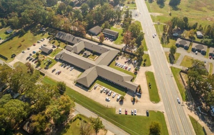 Aerial view of a suburban area with buildings and a parking lot.