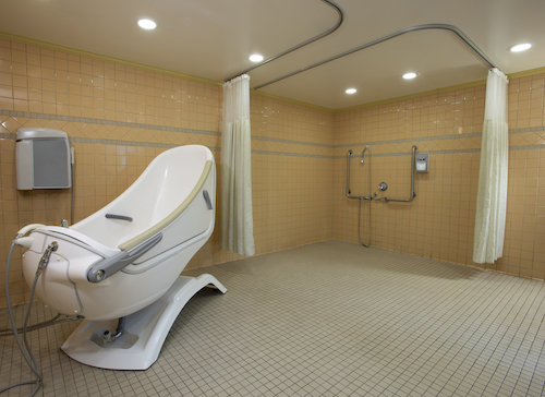 A modern, spacious bathroom featuring a stylish shower area and accessible design elements.