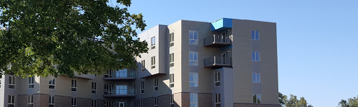 A modern residential building featuring balconies and large windows.