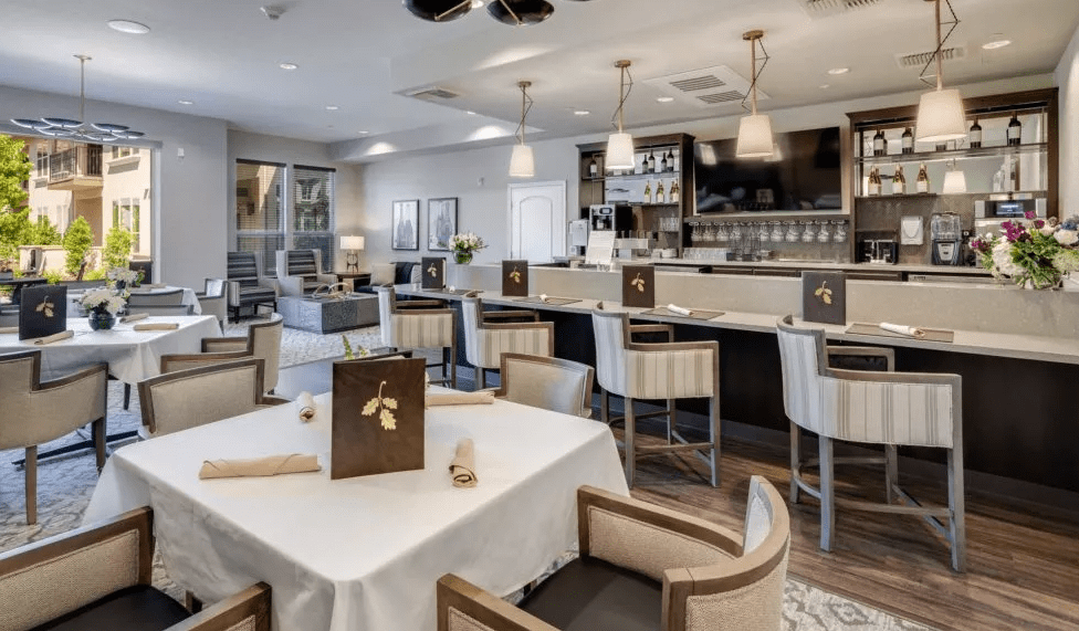 A modern restaurant interior with a bar counter and elegant dining area.