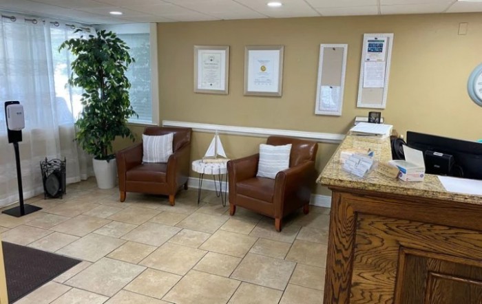 Cozy waiting area with chairs and framed certificates on the wall.