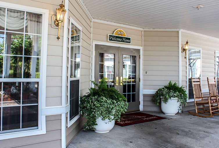 Entrance of a building with decorative plants and double doors.