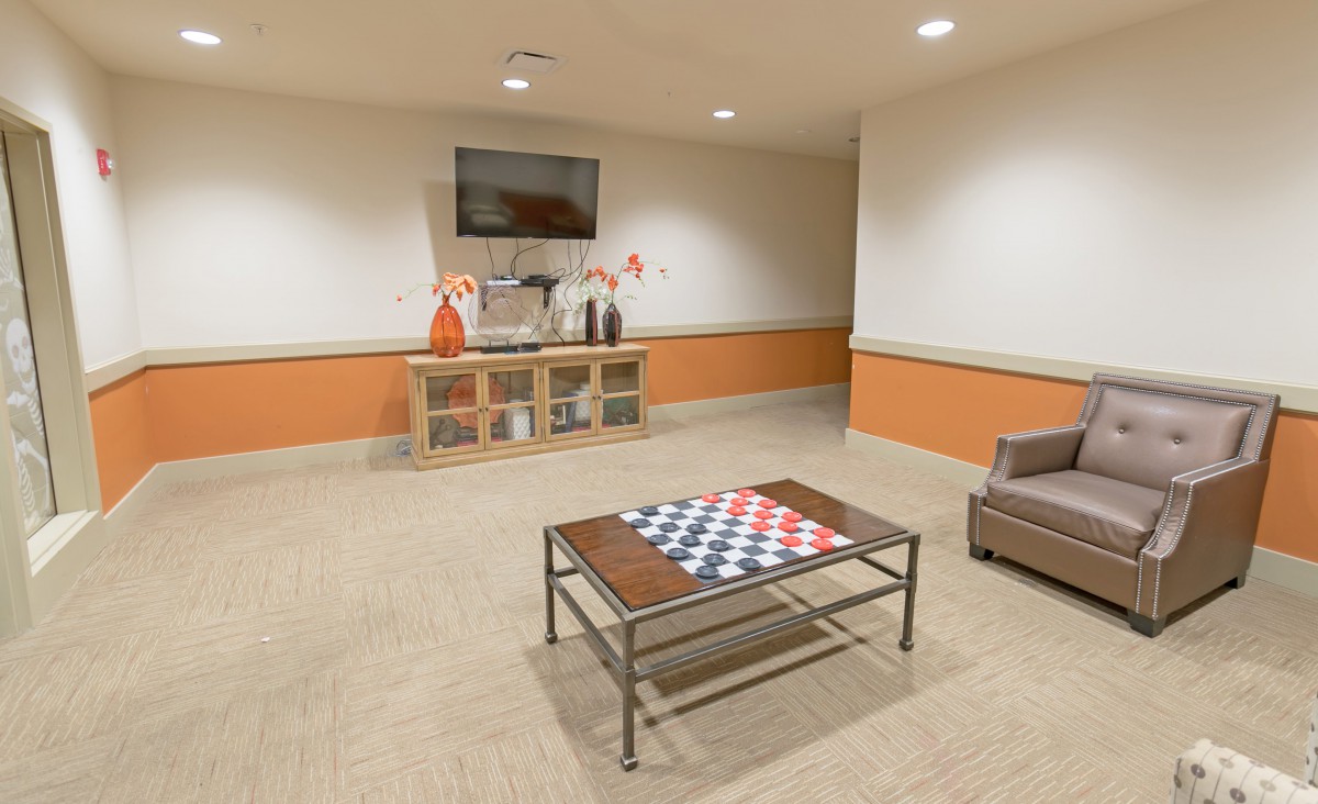 A modern lobby area featuring a TV, decorative items, and comfortable seating.