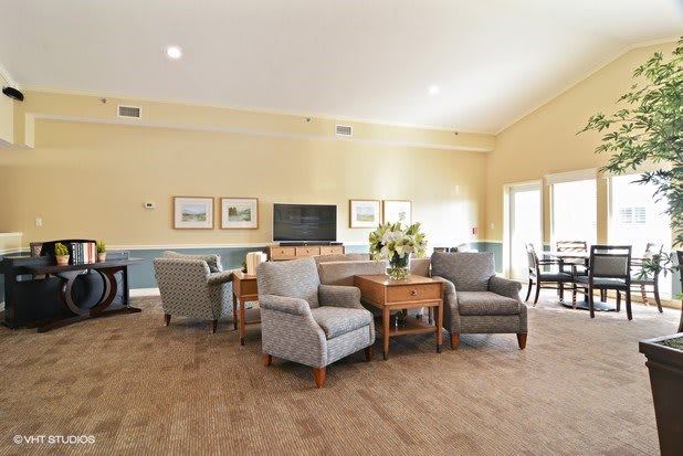 A well-furnished living room with comfortable seating and a television.