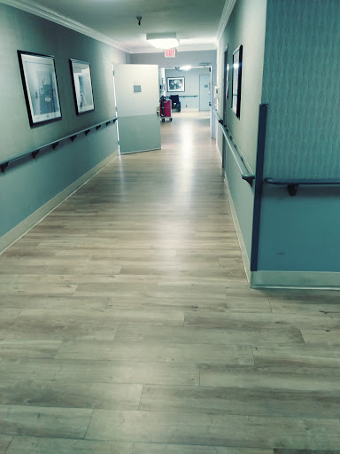 A view of a hospital hallway with light-colored flooring and walls.