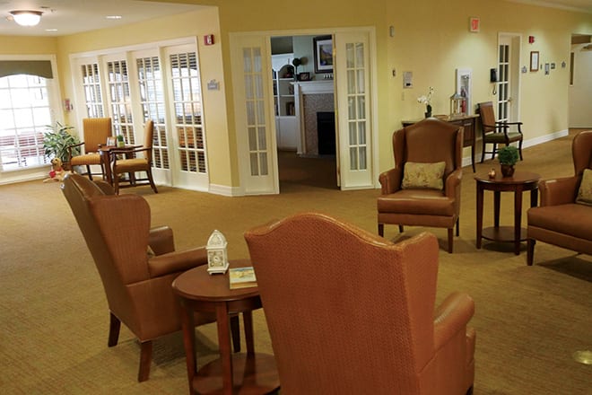 A cozy living room with comfortable chairs and small tables arranged in a seating area.