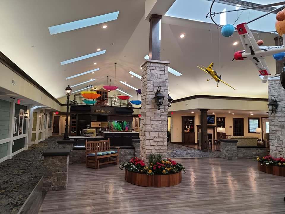 An empty shopping mall with skylights and colorful decorations.