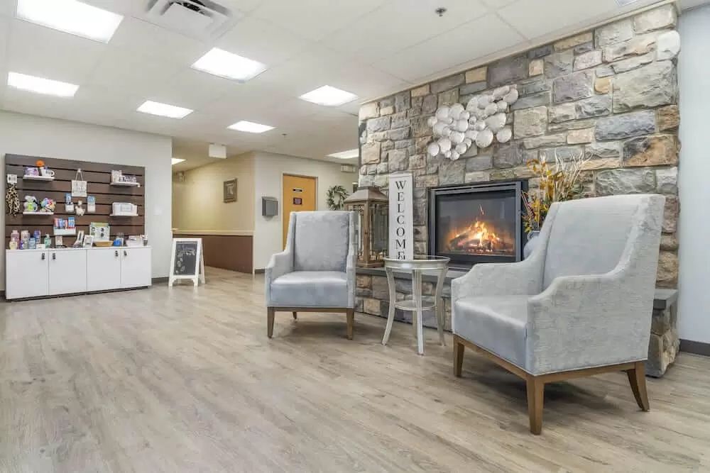 A cozy lobby with a fireplace and modern seating.