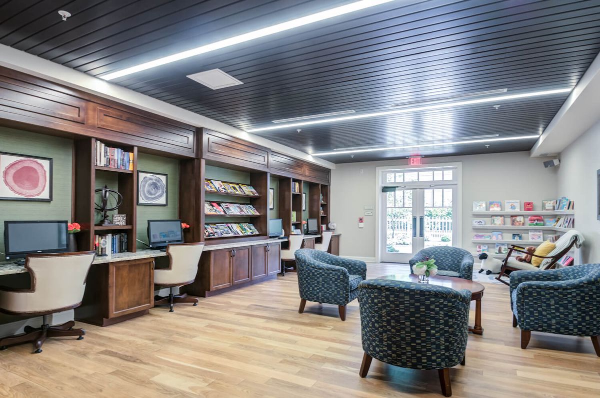 A modern library interior with bookshelves and a comfortable seating area.