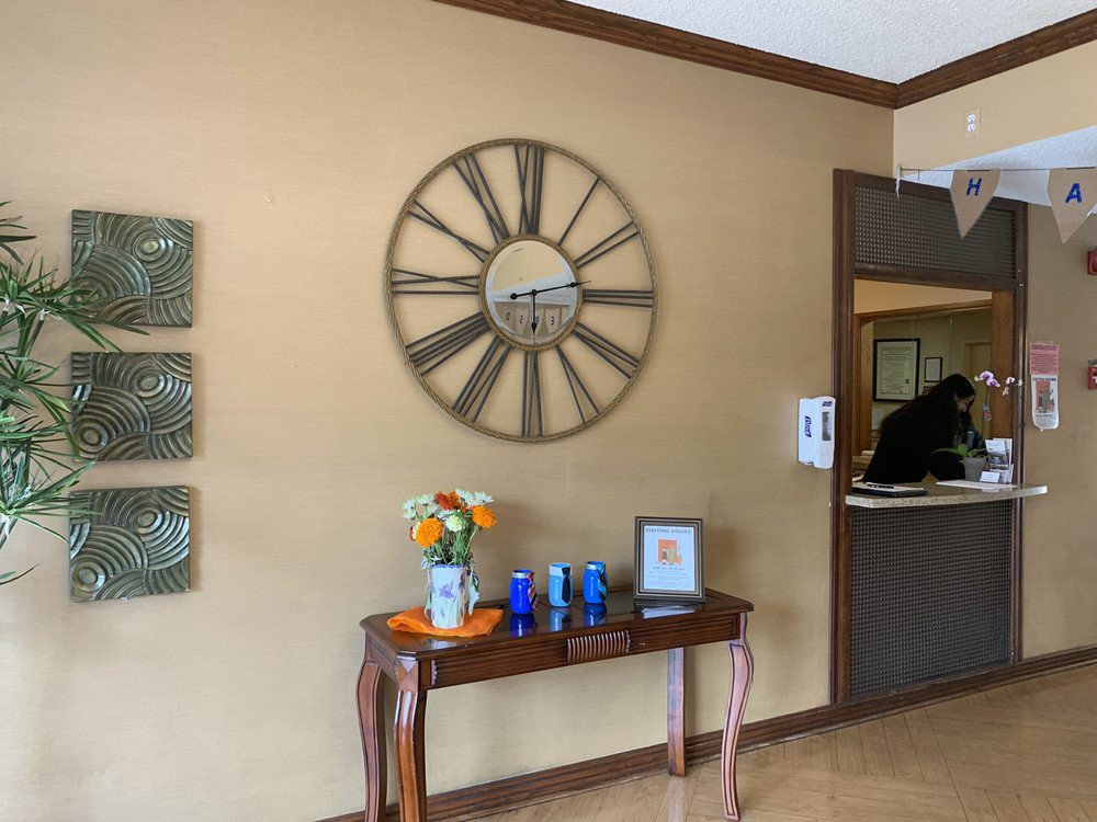 A cozy waiting room with a large wall clock and elegantly decorated table.