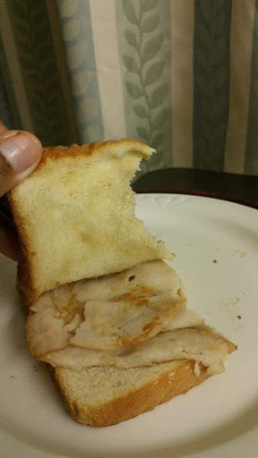 A slice of bread with a bite taken out, revealing the soft interior.