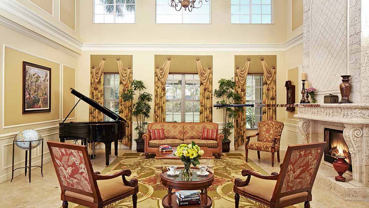 A tastefully decorated living room featuring elegant furniture, a grand piano, and decorative plants.